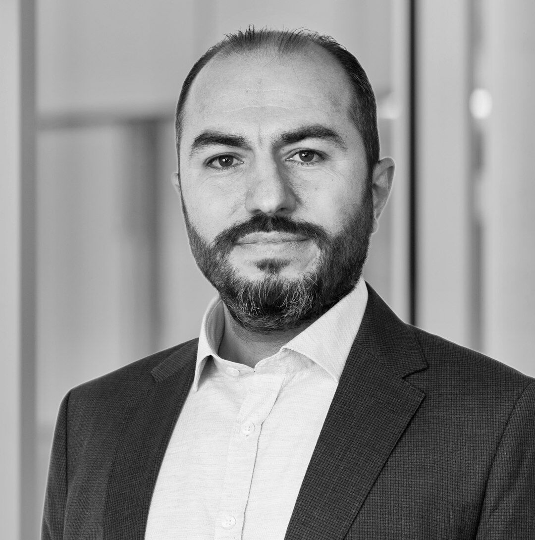 Professional Turkish male AI researcher with glasses